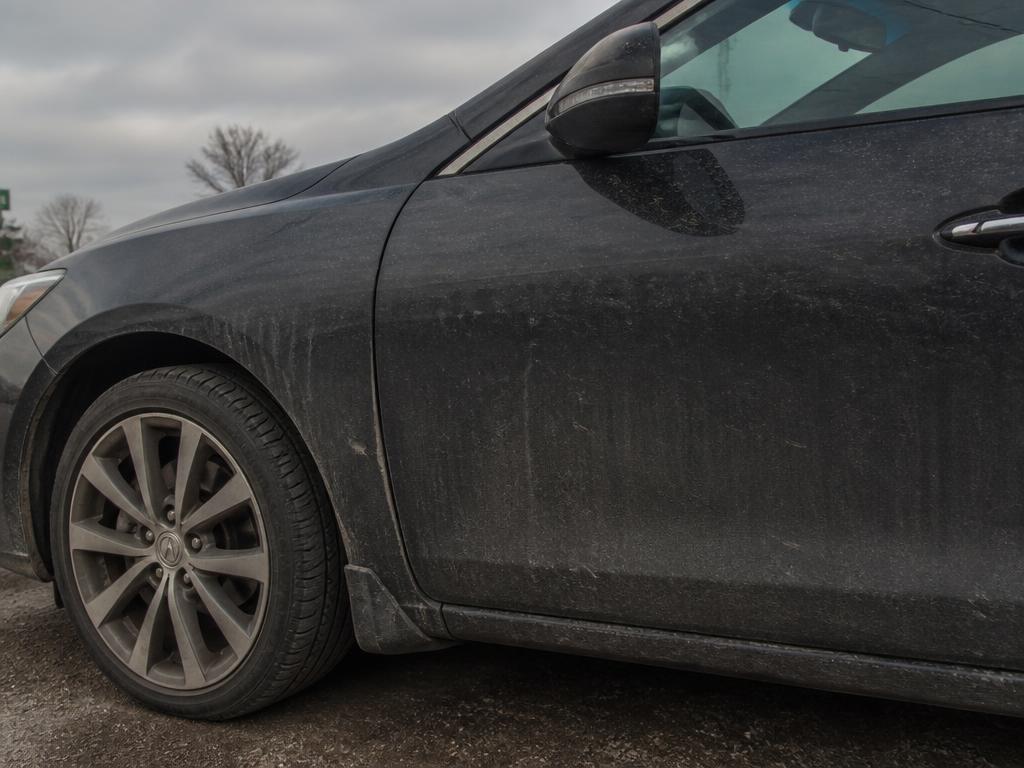 dusty, road-grimed dark car exterior before detailing